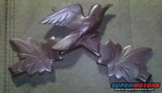 carving of a bird in flight with two leaves
