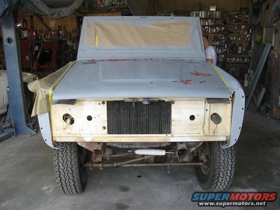 Gray 1966 Ford Bronco body in primer, front view, with grille removed and hood taped