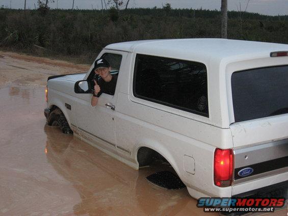 1994 Ford Bronco stuck in mud with driver giving thumbs up
