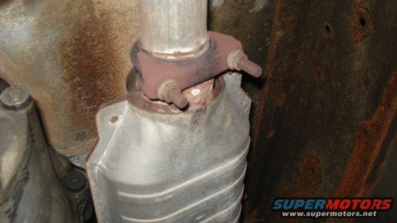 Close-up of a rusty exhaust pipe connection to a catalytic converter