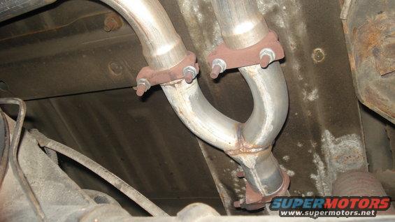 Exhaust Y-pipe with rusty flanges and bolts, viewed from underneath
