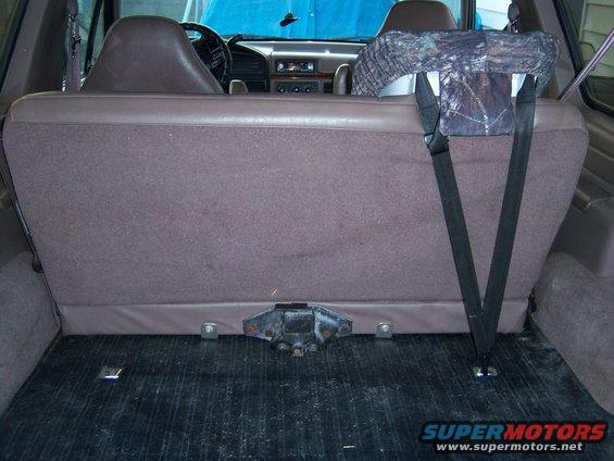 1996 Ford Bronco interior showing rear seats and cargo area with a camouflage seat cover on the headrest