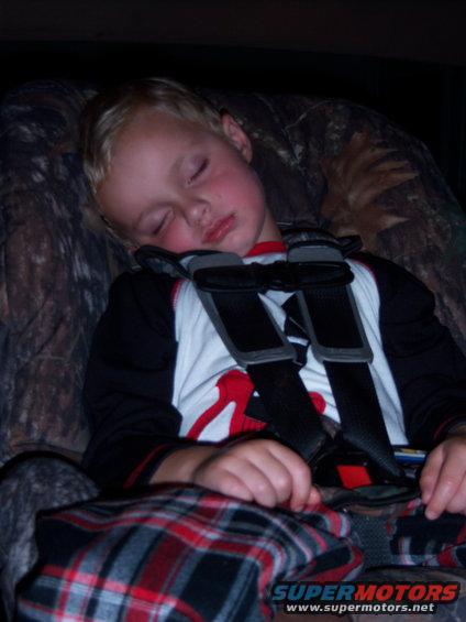 Child sleeping in a car seat with camouflage upholstery