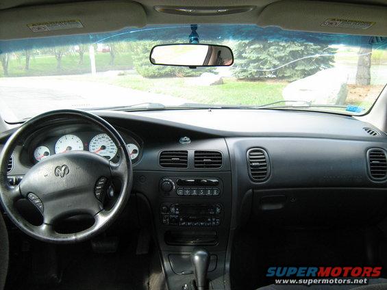 Interior view of a car dashboard with steering wheel, gauges, and center console. Supermotors.net watermark visible