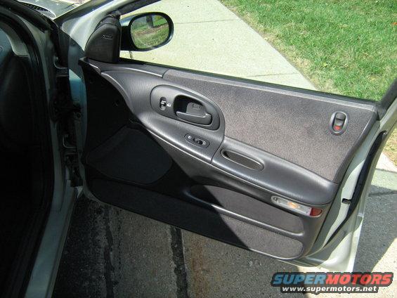 Car door panel with window controls and a side mirror visible