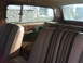 1980 Jeep Cherokee - The interior of a station wagon shows striped seats and brown trim, with a Supermotors logo in the corner.