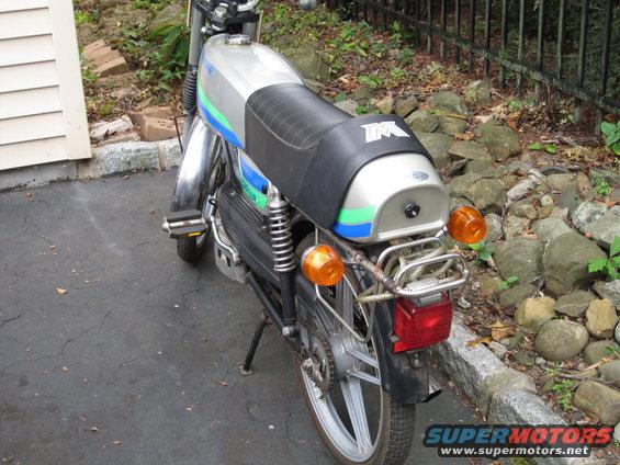 Silver motorcycle with blue and green stripes, rear view