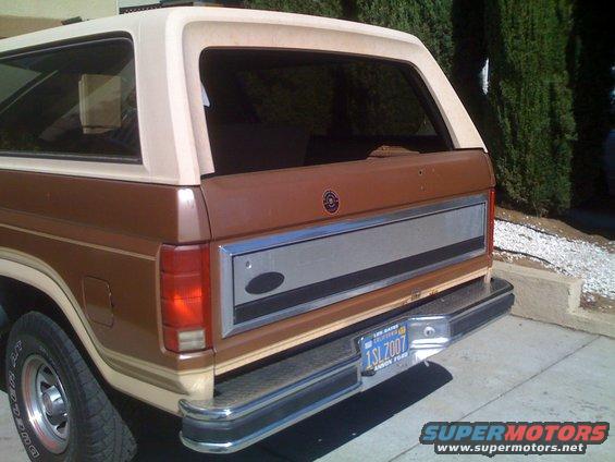 Brown and tan Ford Bronco rear quarter panel with chrome bumper and California license plate
