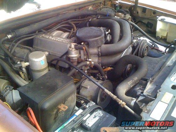 Engine bay with large hoses and engine components visible
