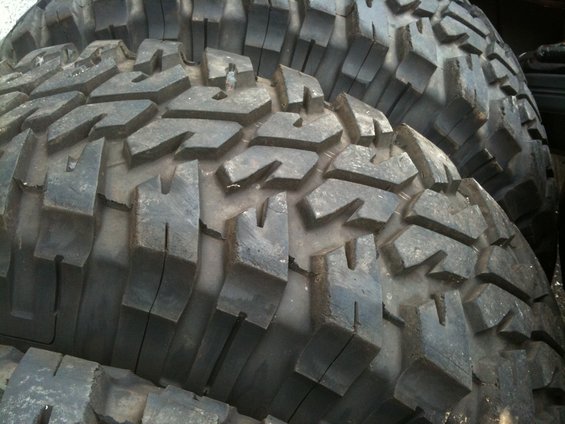 Close-up of stacked off-road tires with aggressive tread pattern