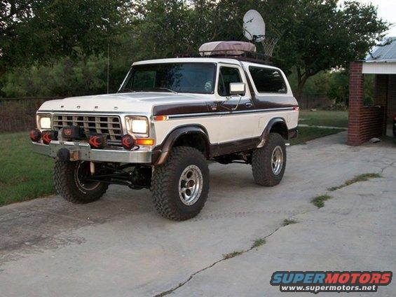 White and brown 1978 Ford Bronco with roof rack and satellite dish
