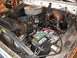 1978 Ford Bronco - The engine bay of a 1978 Ford Bronco shows its V8 engine, battery, and other components.
