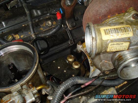 Engine bay with turbocharger, oil filter housing, and wiring. Rusty turbocharger