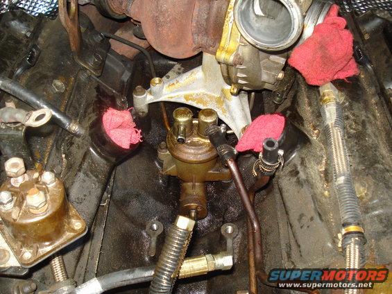 Engine bay with fuel filter, turbocharger, and some red rags stuffed into openings