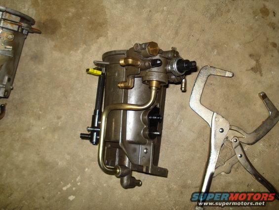 Metal fuel filter housing with brass fittings and a locking clamp on a concrete surface
