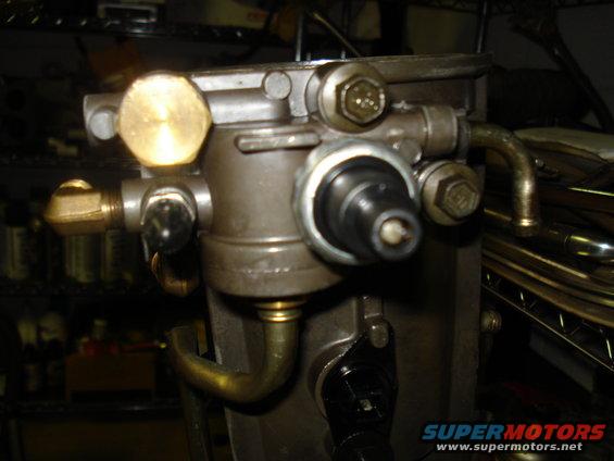 Close-up of a fuel pressure regulator with brass fittings and a black sensor