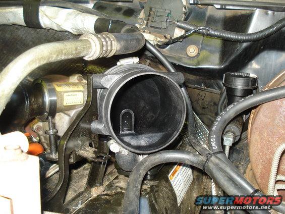 Engine intake manifold and hoses with a yellow label on a component