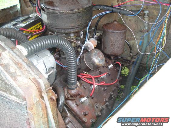 Engine bay with a V8 engine, battery, alternator, and extensive wiring