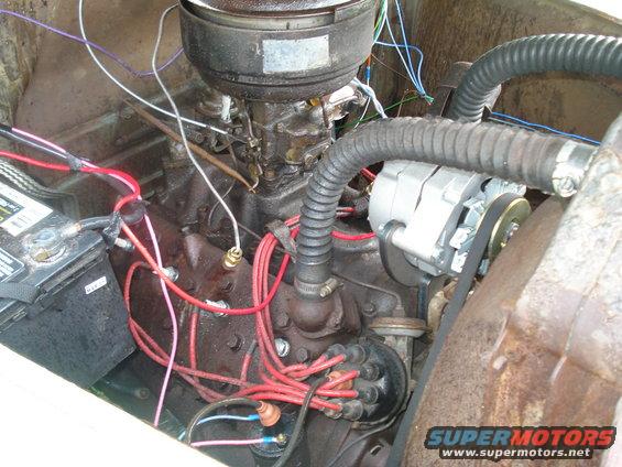 Engine bay with visible wiring, battery, and alternator