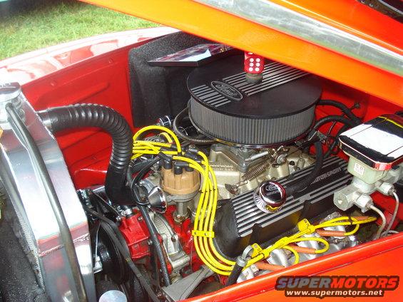 Engine bay with Ford air cleaner and V8 engine. Red and orange paint