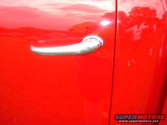 Close-up of a red truck's side door handle