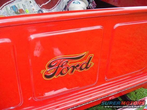 Red Ford tailgate with script logo. Visible text: SUPERMOTORS.NET