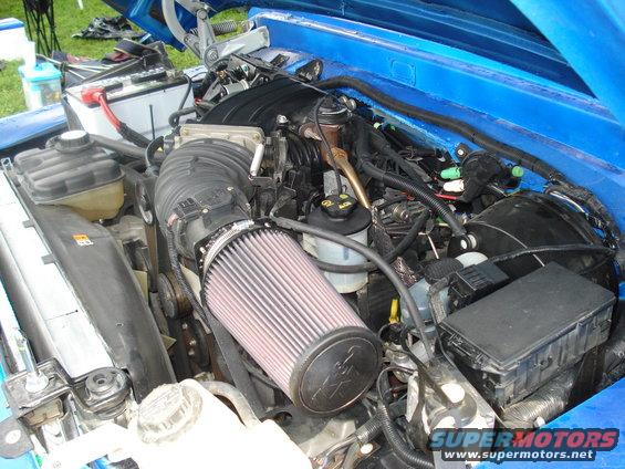 Engine bay showing a K&N air filter, battery, and various hoses and wiring
