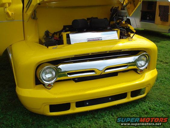 Yellow 1956 Ford F-100 front end with hood open, showing engine and chrome grille