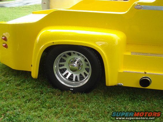 Yellow custom pickup truck bed with chrome wheels and dual taillights