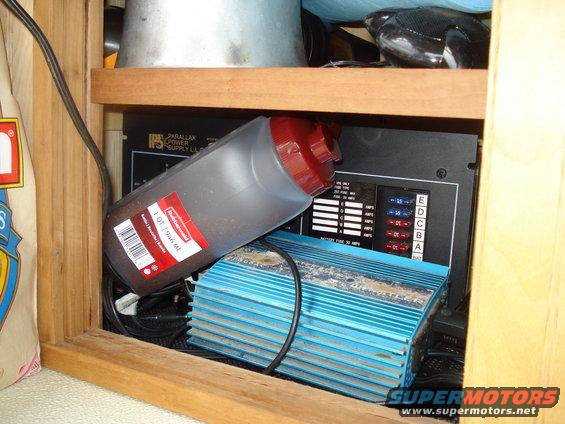 RV interior with a red-capped bottle on top of a blue electrical component and a black fuse box