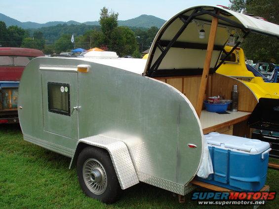 Aluminum teardrop trailer with open galley kitchen and blue cooler