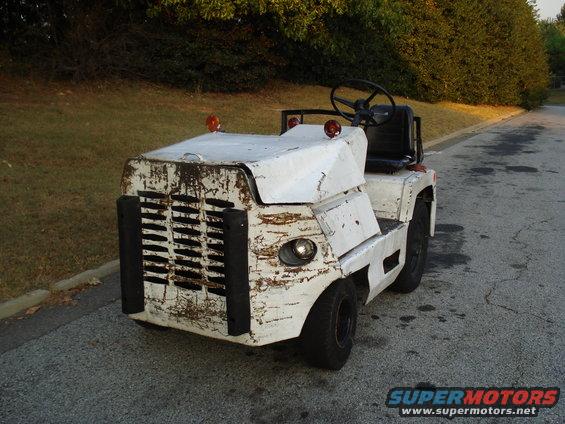 White tow tractor with a distressed paint job and black grille