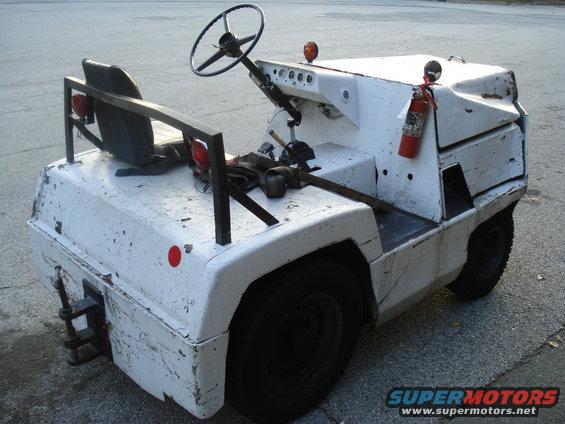 White airport tow tractor with a fire extinguisher mounted on the side