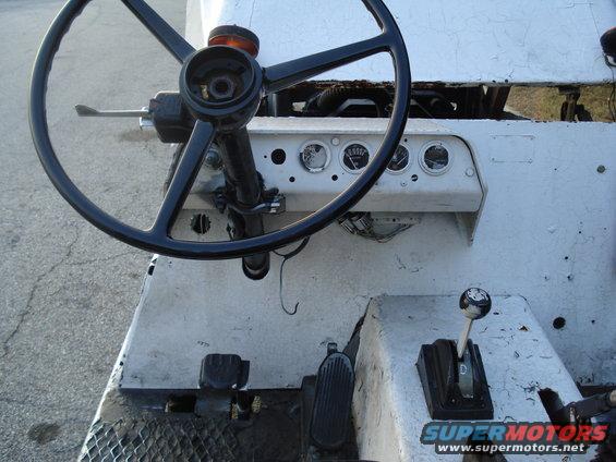 Interior view of a vehicle's dashboard, steering wheel, and gear shifter