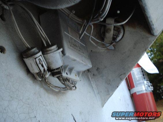 White truck undercarriage with electrical box, connectors, and red fire extinguisher