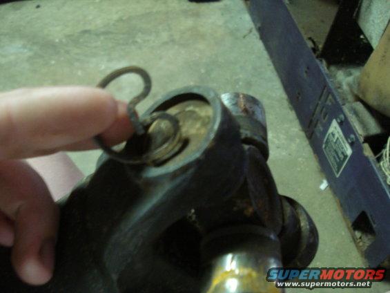 Close-up of a universal joint with a cotter pin being held by a finger