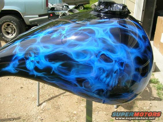 Motorcycle gas tank painted with blue flames and a skull design