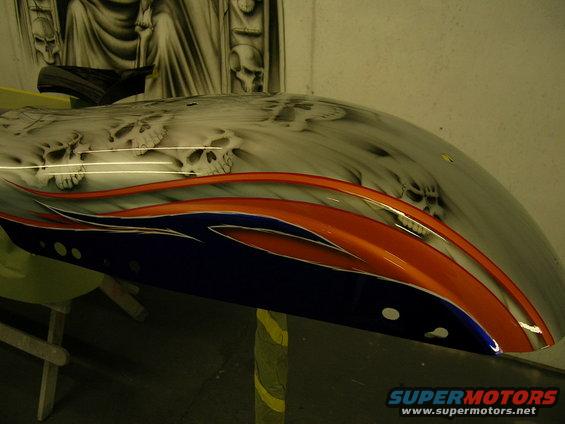 Motorcycle fender with skull airbrushing and orange and blue flame graphics
