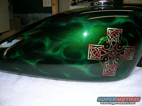 Motorcycle fuel tank with green flame airbrushing and a Celtic cross decal