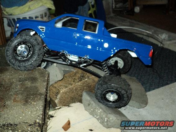 Blue RC truck with large tires on a rocky obstacle course