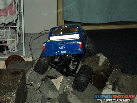blue RC truck on rocks, has a Ford logo on the tailgate