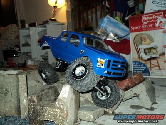Blue 2008 Ford F-250 RC truck with large tires on concrete blocks