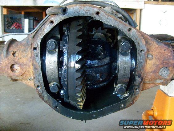Differential housing with gears exposed, showing rust and black grease