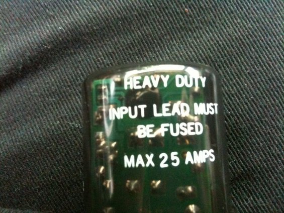Close-up of a heavy duty electrical part with text reading 'INPUT LEAD MUST BE FUSED MAX 25 AMPS'