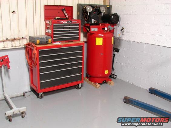 red tool chest and large red air compressor in a garage