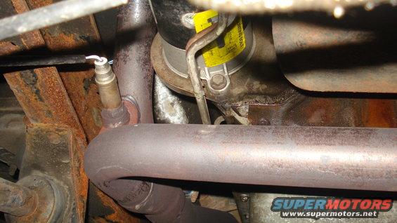 Exhaust pipe with oxygen sensor and yellow tag on catalytic converter