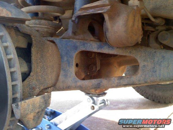 Close-up of rusty vehicle suspension components on a jack