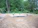 1994 Ford Escort - A remote control car is on a dirt track surrounded by pipes and mounds of dirt.