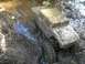 1994 Ford Escort - RC rock crawler navigating a muddy stream, showing off its off-road capabilities.