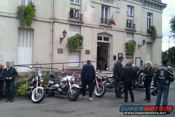 Motorcycles parked in front of a French Mairie building